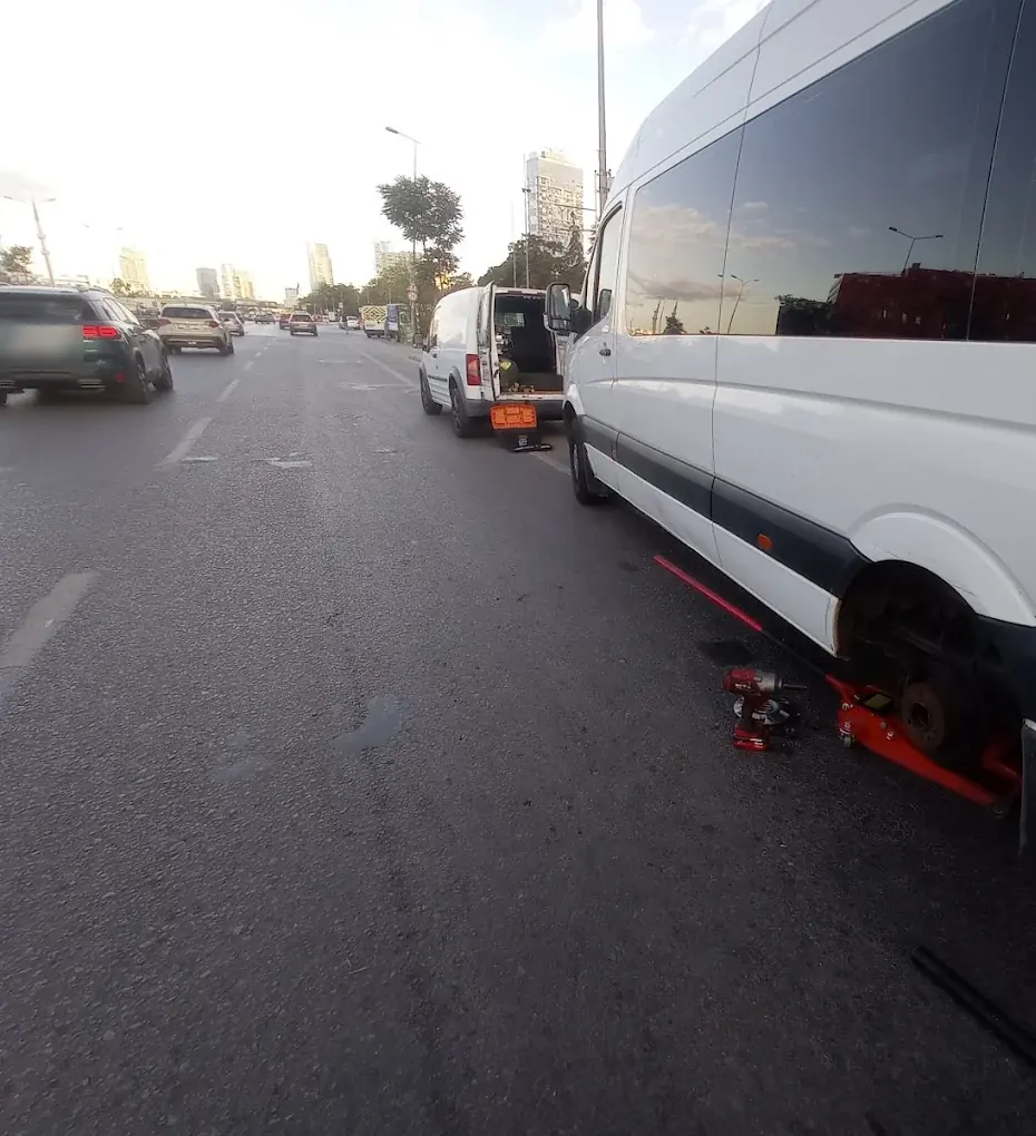 Yol kenarında servis minibüsünde teker değişimi, krikoda duran araç